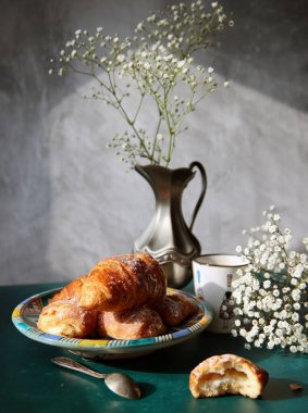 Masada güzel bir kahvaltı. Taze pişmiş kruvasanlar yakın plan fotoğraf. Gıda hala hayat. 