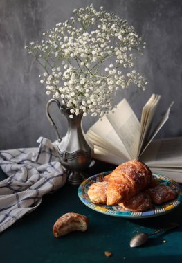 Masada güzel bir kahvaltı. Taze pişmiş kruvasanlar yakın plan fotoğraf. Gıda hala hayat. 