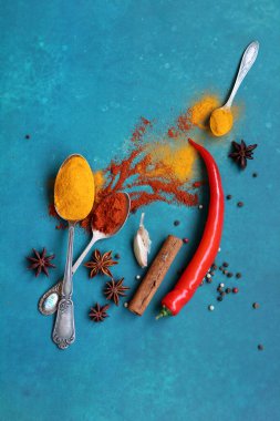 Mavi arka planda farklı aromatik baharatlarla güzel bir kompozisyon. Baharatlı yemek malzemeleri fotoğrafı kapatır. Gıda hala hayat. 
