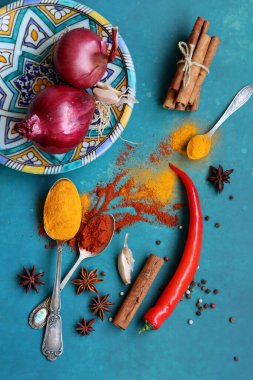 Mavi arka planda farklı aromatik baharatlarla güzel bir kompozisyon. Baharatlı yemek malzemeleri fotoğrafı kapatır. Gıda hala hayat. 