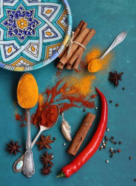 Mavi arka planda farklı aromatik baharatlarla güzel bir kompozisyon. Baharatlı yemek malzemeleri fotoğrafı kapatır. Gıda hala hayat. 