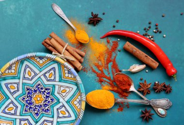 Mavi arka planda farklı aromatik baharatlarla güzel bir kompozisyon. Baharatlı yemek malzemeleri fotoğrafı kapatır. Gıda hala hayat. 