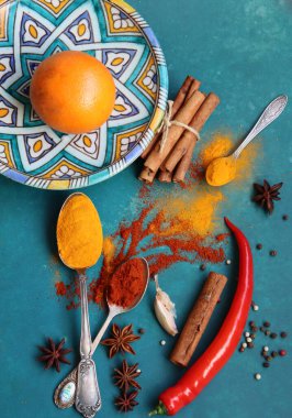 Fotokopi alanı olan canlı mavi arka planda farklı baharatlara sahip renkli natürmort yaşam. Paprika, zerdeçal, tarçın, anason, biber ve sarımsak.. 