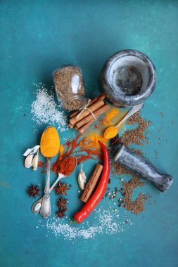 Mavi arka planda farklı aromatik baharatlarla güzel bir kompozisyon. Baharatlı yemek malzemeleri fotoğrafı kapatır. Gıda hala hayat. 