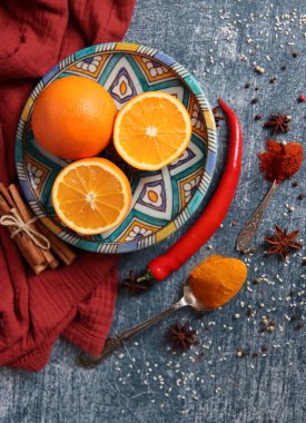 Koyu gri arkaplandaki sulu portakallar ve baharatlar fotokopi alanı içeriyor. Zerdeçal, paprika tozu, kırmızı biber ve taze meyve renkleri. Sağlıklı yeme kavramı. 