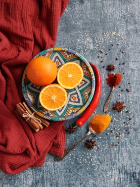 Koyu gri arkaplandaki sulu portakallar ve baharatlar fotokopi alanı içeriyor. Zerdeçal, paprika tozu, kırmızı biber ve taze meyve renkleri. Sağlıklı yeme kavramı. 