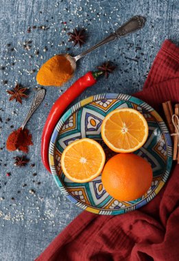 Koyu gri arkaplandaki sulu portakallar ve baharatlar fotokopi alanı içeriyor. Zerdeçal, paprika tozu, kırmızı biber ve taze meyve renkleri. Sağlıklı yeme kavramı. 