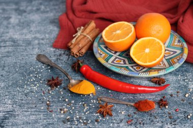 Portakallar, kırmızı biber, kırmızı biber tozu, zerdeçal ve üst görüntü fotoğrafı. Baharatlar masada. Baharatlı yemek hazırlığı yapılıyor. Meyveli renkli natürmort. 