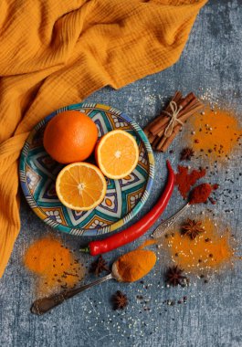 Portakallar ve baharatlarla hayat dolu. Aroma baharatlarının renkli görüntüsü. Kopya alanı ile koyu gri desenli arkaplan. 