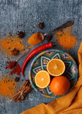 Portakallar ve baharatlarla hayat dolu. Aroma baharatlarının renkli görüntüsü. Kopya alanı ile koyu gri desenli arkaplan. 