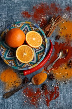 Portakallar, kırmızı biber, kırmızı biber tozu, zerdeçal ve üst görüntü fotoğrafı. Baharatlar masada. Baharatlı yemek hazırlığı yapılıyor. Meyveli renkli natürmort. 
