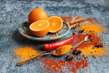 Portakallar ve baharatlarla hayat dolu. Aroma baharatlarının renkli görüntüsü. Kopya alanı ile koyu gri desenli arkaplan. 