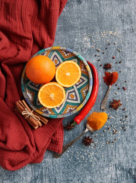 Koyu gri arkaplandaki sulu portakallar ve baharatlar fotokopi alanı içeriyor. Zerdeçal, paprika tozu, kırmızı biber ve taze meyve renkleri. Sağlıklı yeme kavramı. 