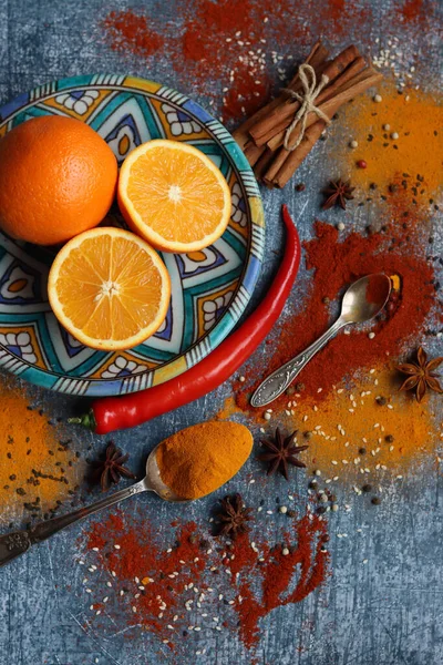 Portakallar ve baharatlarla hayat dolu. Aroma baharatlarının renkli görüntüsü. Kopya alanı ile koyu gri desenli arkaplan. 