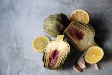 Gri desenli masada pişmemiş enginarlar. Enginar çiçek dokusunun yakın fotoğrafını çek. Dengeli diyet kavramı. 