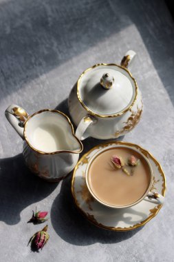 Klasik şeker kasesi, sütlü sürahi ve açık gri arka planda güzel. Masadaki gölgeler. Retro seramik tabloların fotoğrafını kapat. 