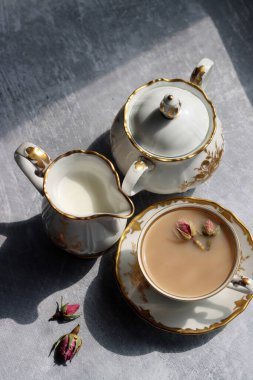 Klasik şeker kasesi, sütlü sürahi ve açık gri arka planda güzel. Masadaki gölgeler. Retro seramik tabloların fotoğrafını kapat. 