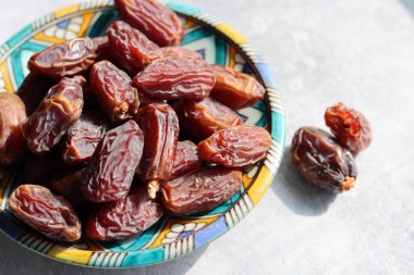 Mavi seramik tabakta kurumuş tarihler. Masadaki tatlı randevuların fotoğrafını çek. sağlıklı yeme kavramı. 