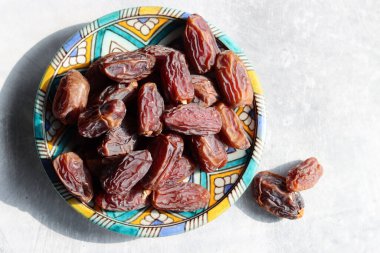 Mavi seramik tabakta kurumuş tarihler. Masadaki tatlı randevuların fotoğrafını çek. sağlıklı yeme kavramı. 
