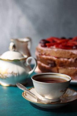 Siyah çay, çilekli pasta ve dokulu taze böğürtlen. Tatlı yemek hala hayattadır. Doğum günü pastası. Fotoğrafı kapat.. 