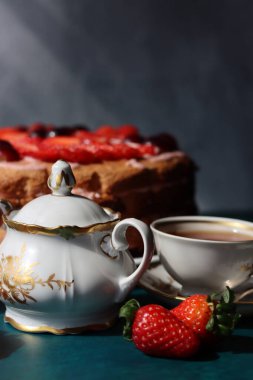 Siyah çay, çilekli pasta ve dokulu taze böğürtlen. Tatlı yemek hala hayattadır. Doğum günü pastası. Fotoğrafı kapat.. 