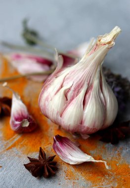 Baharatlar masada. Sarımsak karanfili ve ampul, zerdeçal tozu, biberiye, anason ve lavanta yakın fotoğraf. Açık gri arkaplan. 
