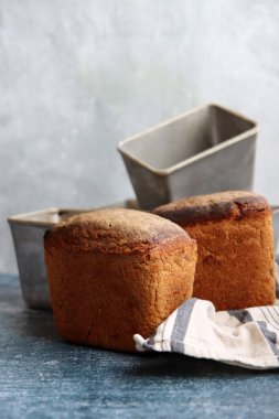 Masadaki dikdörtgen ekmek ve alüminyum formlar. Taze ev yapımı çavdar ekmeği. Yakın plan.. 