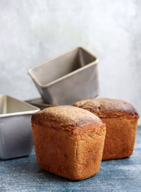 Masadaki dikdörtgen ekmek ve alüminyum formlar. Taze ev yapımı çavdar ekmeği. Yakın plan.. 