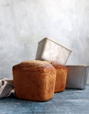 Masadaki dikdörtgen ekmek ve alüminyum formlar. Taze ev yapımı çavdar ekmeği. Yakın plan.. 