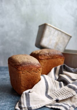 Masadaki dikdörtgen ekmek ve alüminyum formlar. Taze ev yapımı çavdar ekmeği. Yakın plan.. 