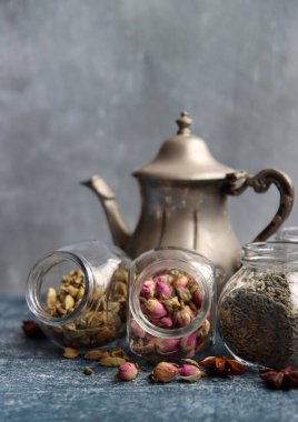 Çaydanlık ve cam kavanoz baharatlarla dolu sakin bir hayat. Siyah çay, karanfil, kakule. Tarçın, anason yıldızları ve lavanta rengi üst manzara fotoğrafı. Geleneksel baharatlı çay.. 