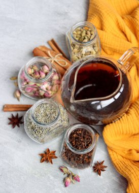 Çaydanlık ve cam kavanoz baharatlarla dolu sakin bir hayat. Siyah çay, karanfil, kakule. Tarçın, anason yıldızları ve lavanta rengi üst manzara fotoğrafı. Geleneksel baharatlı çay.. 