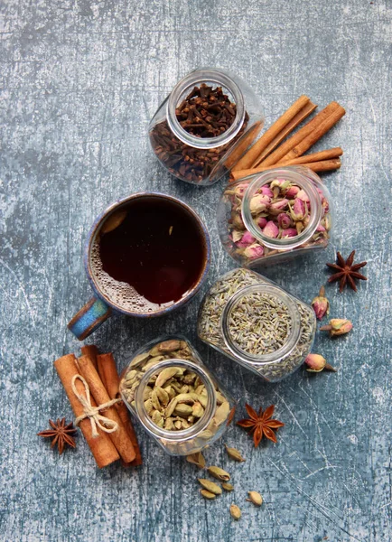 Farklı çay çeşnileri üst görünüm fotoğrafı. Tarçın, anason, kakule, karanfil, lavanta, masada güller. Aromatik çay yakın çekim. Doğal antioksidan kavramı. 