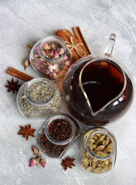 Çaydanlık ve cam kavanoz baharatlarla dolu sakin bir hayat. Siyah çay, karanfil, kakule. Tarçın, anason yıldızları ve lavanta rengi üst manzara fotoğrafı. Geleneksel baharatlı çay.. 