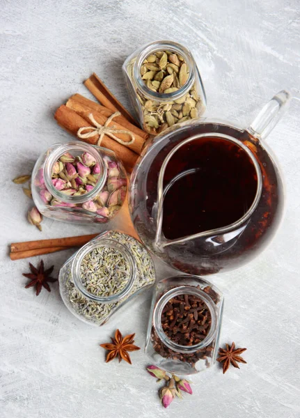 Çaydanlık ve baharatlar açık gri arka planda fotokopi alanı ile birlikte. Masadaki farklı çay çeşitleri. Lavanta, kakule, tarçın, gül, anason yıldızları ve karanfilli üstten görüntü.. 