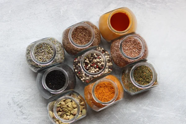 Small Glass Jars Different Spices Peppercorn Cardamom Turmeric Curry Flax — Stockfoto