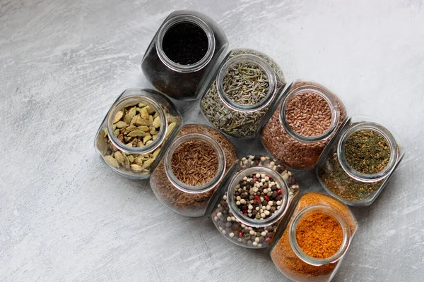 Small Glass Jars Different Spices Peppercorn Cardamom Turmeric Curry Flax — Stockfoto