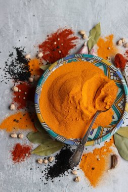 Zerdeçal tozu yakın çekim fotoğrafı. Güzel mavi seramik tabakta Curcuma baharatı. Hint baharatları. Zerdeçal ile renkli natürmort. 