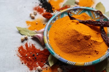Zerdeçal tozu yakın çekim fotoğrafı. Güzel mavi seramik tabakta Curcuma baharatı. Hint baharatları. Zerdeçal ile renkli natürmort. 