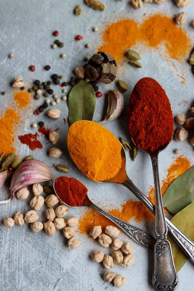 Retro kaşıkların, zerdeçal ve paprika tozuyla yakın plan fotoğrafını çek. Kokulu otların ve baharatların renkli bir fotoğrafı..  