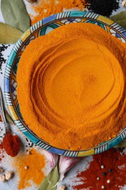 Doğu seramik tabakasında zerdeçal tozu. Baharatlarla dolu bir hayat. Kırmızı biber, tohum, sokağa çıkma yasağı, defne yaprakları ve kırmızı biber. Hint baharatları kapanıyor..  