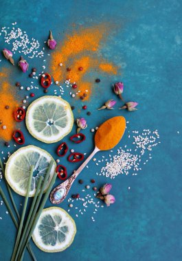 Zerdeçal tozu, limon, biber, deniz tuzu ve canlı mavi arkaplanda yeşil soğan. Aromatik baharatlar fotoğrafı kapatır. Masadaki sağlıklı yemek malzemeleri.. 