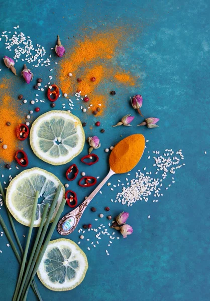 Zerdeçal tozu, limon, biber, deniz tuzu ve canlı mavi arkaplanda yeşil soğan. Aromatik baharatlar fotoğrafı kapatır. Masadaki sağlıklı yemek malzemeleri.. 