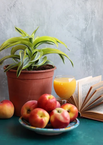 Bir bardak portakal suyu ve taze şeftali ile dolu bir hayat. Yaz meyvesi yakın çekim fotoğrafı. Kopyalama alanı olan açık gri arkaplan. 