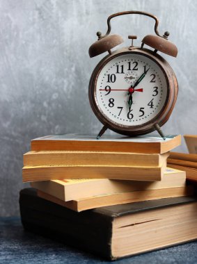 Masada eski kitaplarla dolu bir hayat. Vintage objeler, fotoğrafı kapatın. Fotokopi alanı olan gri arkaplan. Okuma konsepti zamanı. 