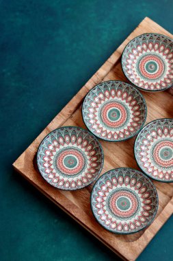 Mandala motifli oryantal seramik tabaklar. Etnik bulaşık takımı, yakın plan fotoğraf. Otantik Arap çömleği. Kopyalama alanı olan mavi arkaplan. 