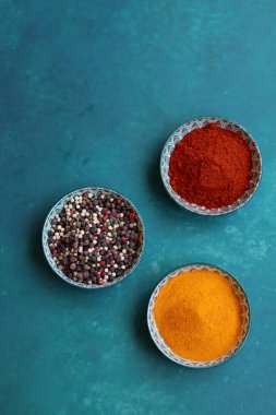 Biber, paprika ve zerdeçal tozlu üç küçük seramik kase. Aromatik Hint baharatlarıyla basit kompozisyon. Sağlıklı yeme kavramı. 