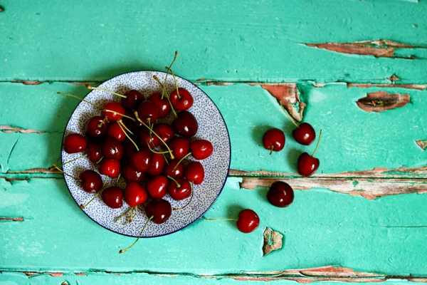 Sweet cherry on a table. Vibrant color of summer fruit. Refreshing summer snack. Top view photo of cherry.