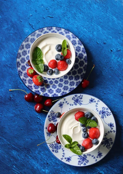 两个酸奶碗和新鲜的夏季浆果 健康的早餐头像照片 蓝色纹理背景 有复制空间 美丽的夏天静谧的生活 健康饮食概念 — 图库照片