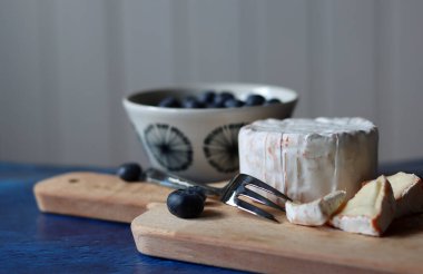 Masadaki Fransız yumuşak peynirinin ve sulu organik meyvelerin yakın plan fotoğrafını çek. Lezzetli aperatiflerin en iyi görüntüsü. Yemek natürmort fotoğrafı. Kopyalama alanı olan desenli arkaplan. 